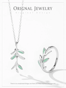 Close-up of S925 silver leaf necklace and open ring set with green enamel details