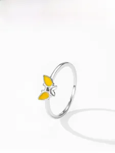 Détail d'une bague papillon en argent avec émail jaune et anneau fin