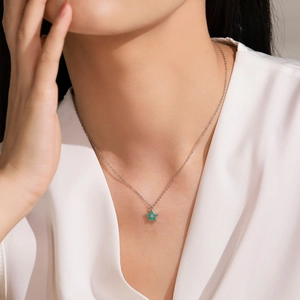 Collier étoile verte en argent 925 porté par un mannequin sur un haut en soie