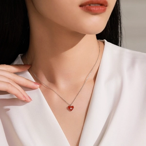 Collier vintage français en argent 925 avec un pendentif cœur rouge porté par un modèle