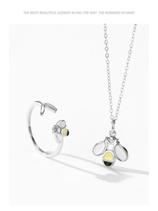 Detailed macro view of 925 silver bee ring and matching necklace set with enamel wings