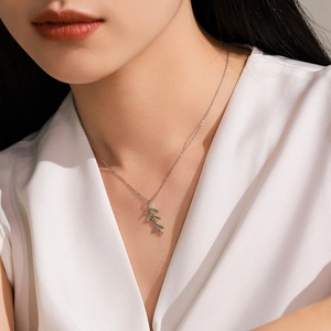 Elegant S925 silver necklace with green enamel leaf pendant worn on a female neck