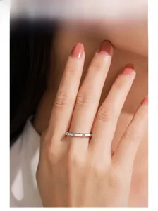 Detail shot of a silver ring with screw motifs and round diamonds on a model's hand