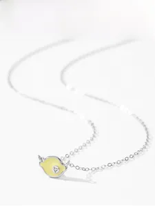 Macro shot of 925 sterling silver lemon pendant with yellow enamel and small crystal