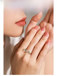 Detailed view of wave-shaped 925 sterling silver ring with colorful rainbow enamel on finger