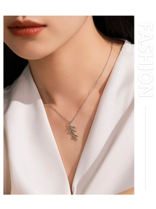 Close-up of S925 silver leaf necklace with green enamel on a model wearing white