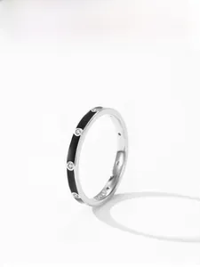 Macro detail of 925 silver ring featuring black enamel lines and sparkling clear zircons
