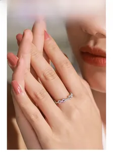 Détail d'une bague infini en argent S925 avec émail rose et cristaux sur le doigt