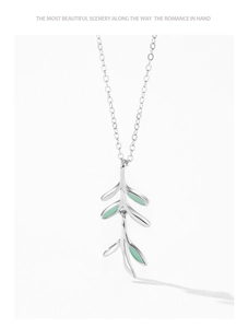 Detail of silver S925 necklace featuring delicate green enamel leaf branch pendant