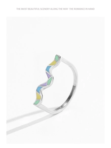 Close-up of wavy 925 silver ring with colorful rainbow enamel inlay on white background