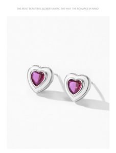 Macro detail of 925 sterling silver heart stud earring with purple zircon and enamel
