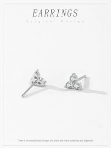 Macro shot of 925 silver stud earrings featuring three tiny zircon stones in a triangle