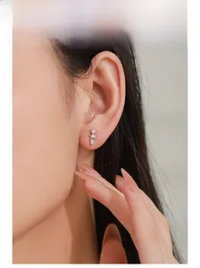 Close-up of 925 sterling silver teardrop cubic zirconia earrings on model ear