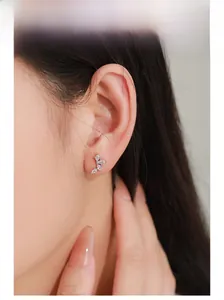 Close-up of S925 silver wing stud earrings with sparkling cubic zirconia on model