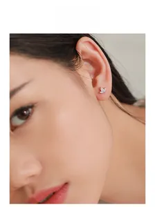 Close-up of sparkling cubic zirconia butterfly earrings worn on model's earlobe