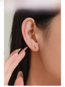 Macro side view of double square-cut zircon studs on ear in S925 sterling silver