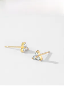 Macro view of gold-plated triangle studs featuring three sparkling zircon stones