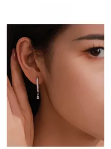 Close-up of model wearing silver U-shaped teardrop earrings with sparkling zircons