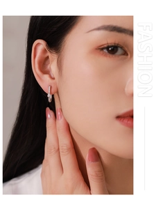 Détail des boucles d'oreilles géométriques en U argentées avec zircons étincelants