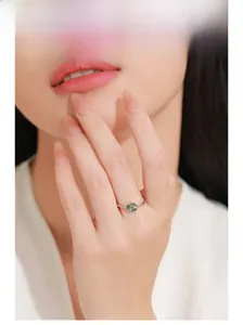 Close-up of model wearing 925 silver ring with three olive green marquise gemstones