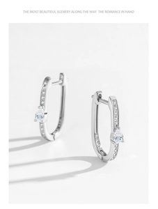 Gros plan sur boucles d'oreilles en U argent 925 avec pierre poire et pavage en zircon