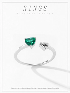 Detailed macro view of 925 sterling silver bypass ring with emerald heart stone