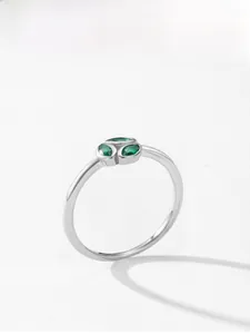 Macro detail of 925 silver ring featuring three marquise-cut green gemstones on white