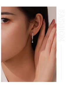 Close-up of S925 silver U-shaped hoop earring with zircon inlay and teardrop pendant