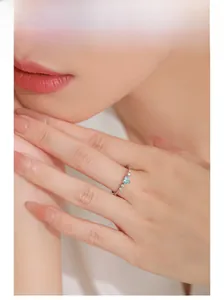 Close-up of S925 silver ring with ice blue heart stone on model's slender finger