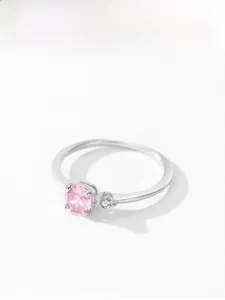 Détail d'une bague en argent 925 avec une pierre rose ronde et des zircons blancs