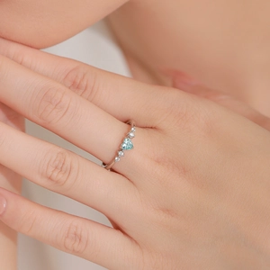 S925 sterling silver ring featuring a blue heart gemstone with side diamonds on finger
