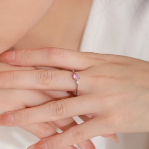 Bague en argent 925 avec pierre rose ronde et zircon sur une main de femme