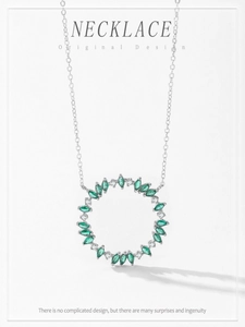 Macro view of sterling silver leaf wreath pendant with green gems and white diamonds