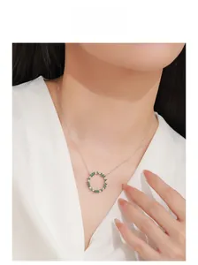 Close-up of 925 silver necklace with marquise green stone and diamond leaf pendant