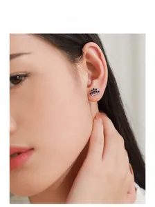 Close-up of elegant crown earrings with blue zircon stones worn by a female model