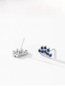 Macro shot of S925 silver crown stud earrings with blue sapphire and white zircon gems