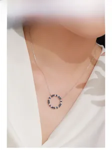 Détail du pendentif tournesol en argent 925 avec pierres bleues sur le mannequin