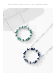 Close-up of 925 sterling silver necklaces with emerald and sapphire floral pendants