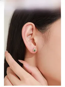Gros plan d'une puce d'oreille en argent S925 avec gemme marquise verte et zircons jaunes