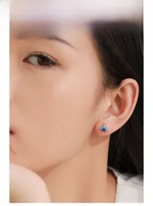 Close-up of model wearing 925 silver bee stud earring with blue marquise gemstones