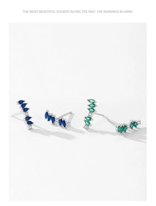 Macro detail of curved S925 silver stud earrings with blue marquise-cut zircon stones