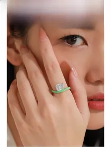 Détail de bague luxueuse avec diamant carré et anneau émaillé vert sur le mannequin
