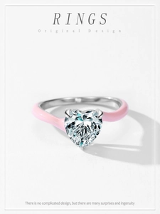 Détail d'une bague en argent et émail rose avec une pierre étincelante taillée en cœur