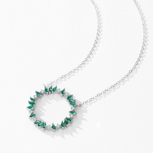 925 silver wreath necklace with emerald green stones and diamonds on white surface
