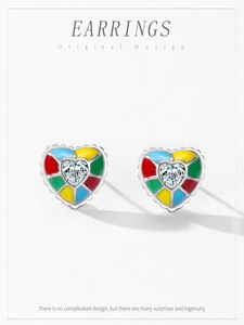 Détail macro de boucles d'oreilles cœur en argent avec émail coloré et zircon