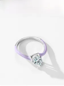 Macro shot of 925 silver ring with pear-cut zircon and purple enamel band details