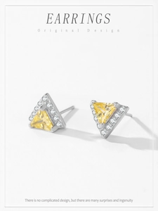 Detailed macro view of 925 sterling silver triangle earrings with yellow zircon and diamonds