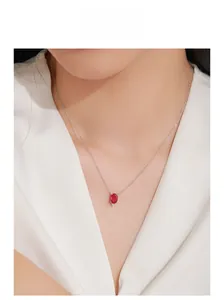 Detail of garnet red zircon pendant necklace on neck showing delicate oval gemstone