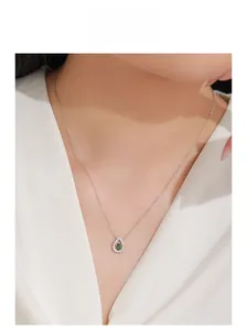 Détail d'un collier en argent 925 avec pendentif goutte en zircon émeraude sur un modèle
