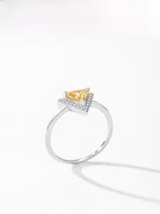 Macro detail of V-shaped silver ring featuring a yellow triangle gemstone and tiny diamonds